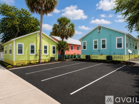 A parking lot with a row of colorful buildings.