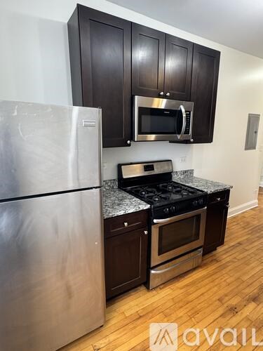 A kitchen with a stainless steel refrigerator and a stove top oven.