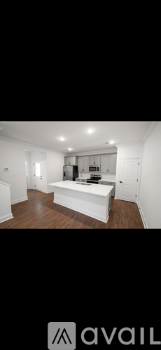 A spacious kitchen with white cabinets and a large island.