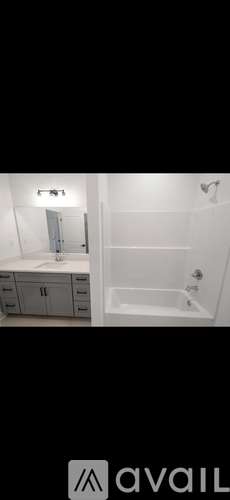 A bathroom with a white tub and a white cabinet with drawers.