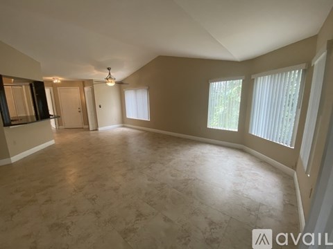 A spacious room with a tiled floor and a ceiling fan.