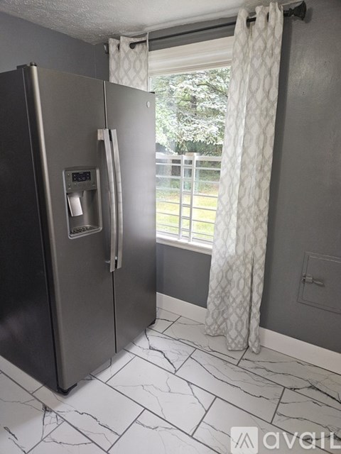 A stainless steel refrigerator with a water and ice dispenser in a kitchen.