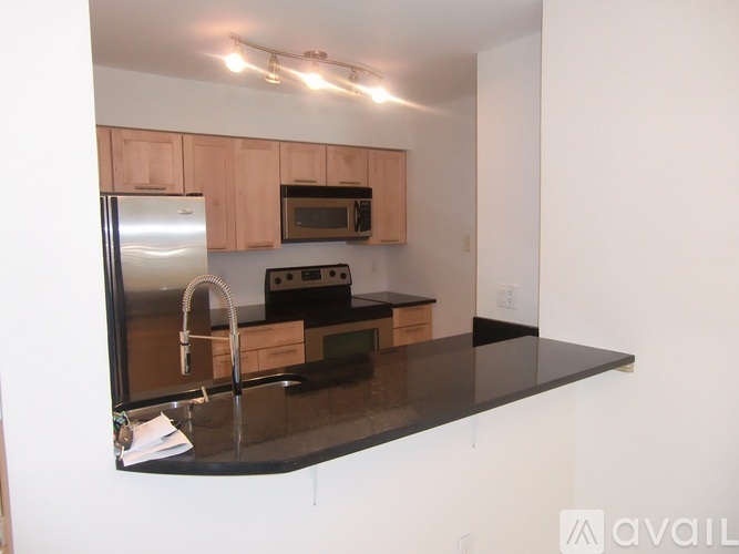 A kitchen with a black countertop and wooden cabinets.