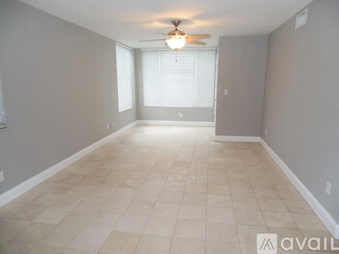 A spacious room with tiled flooring and a ceiling fan.