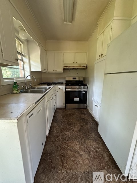 A kitchen with white cabinets and a white fridge.