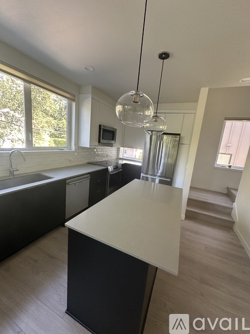 A kitchen with a black counter and a white island.
