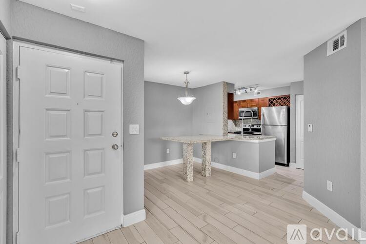 A kitchen area with a table and a refrigerator.