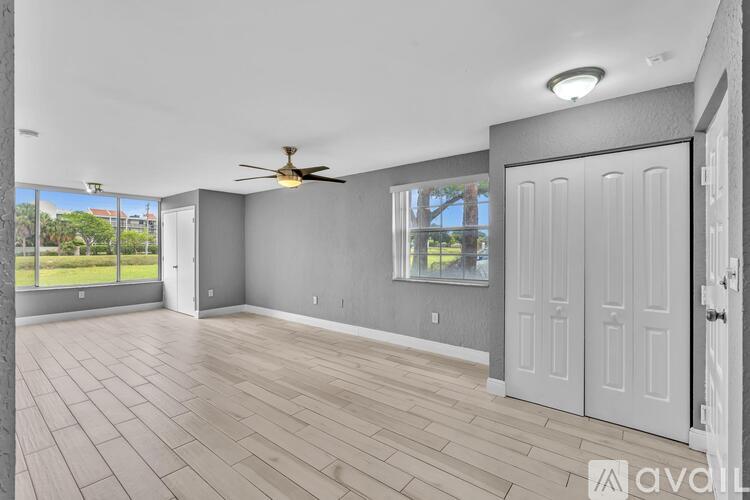 A spacious room with a ceiling fan and sliding glass doors.