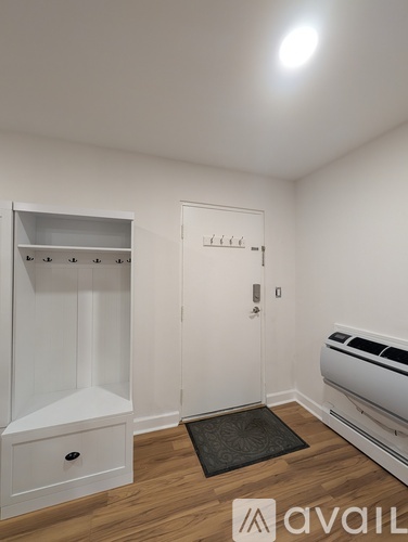 A small white closet with a door and a shelf.