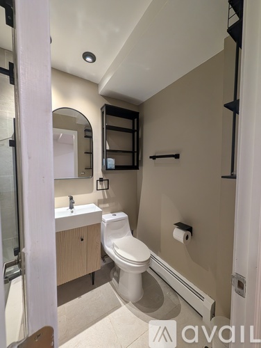 A bathroom with a toilet, sink, and mirror.