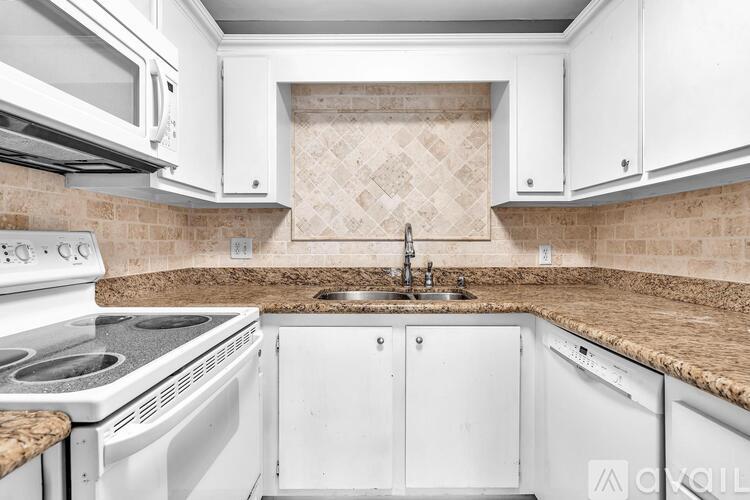 A kitchen with white appliances and cabinets.