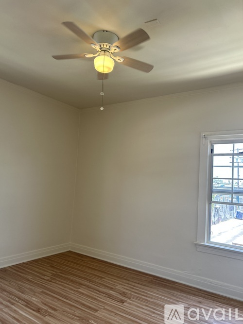 A room with a ceiling fan and a window.