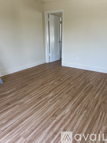 A room with wooden flooring and a door.