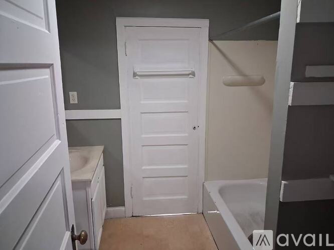 A white door in a room with a grey wall.