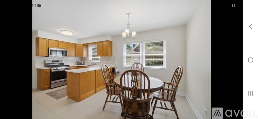 A kitchen with wooden cabinets and a round table with chairs.