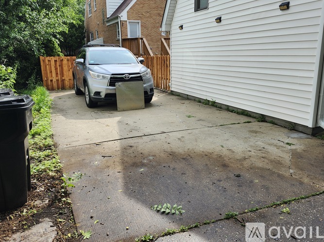 A silver car is parked in a driveway.