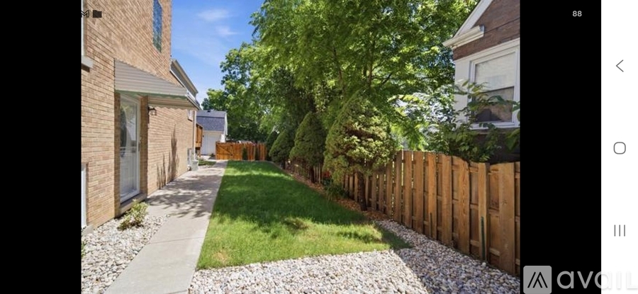 A gravel pathway leads through a grassy area to a wooden fence.