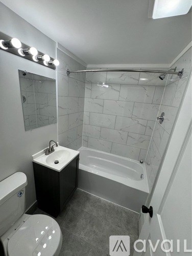 A bathroom with a toilet, sink, and bathtub.