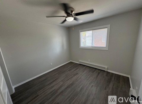 A room with a ceiling fan and a window.