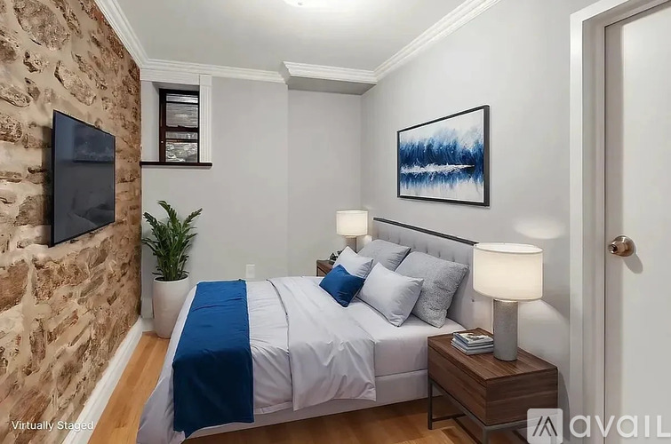 A bedroom with a stone wall and a bed with blue and white bedding.