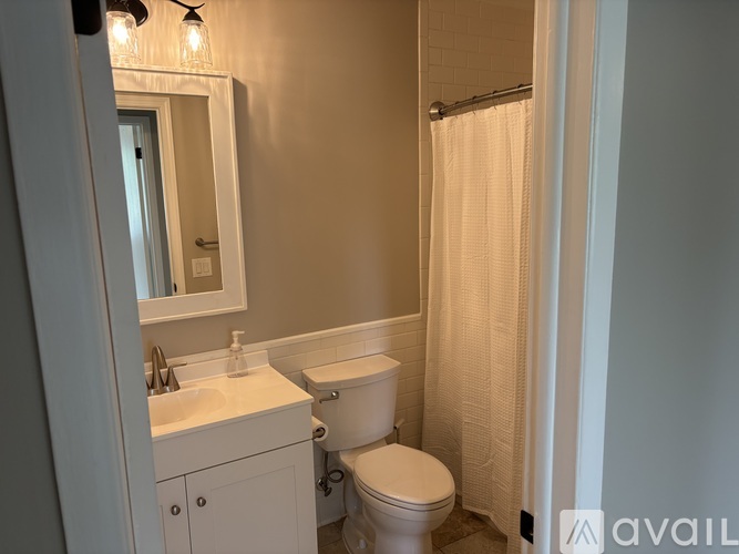 A bathroom with a toilet, sink, and shower.