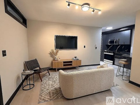 A living room with a couch, a chair, and a television.