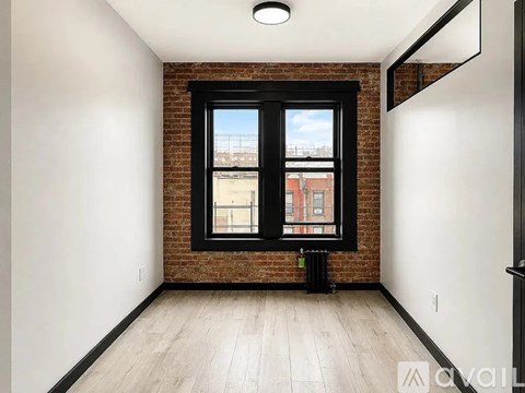A room with a large window and a radiator on the wall.