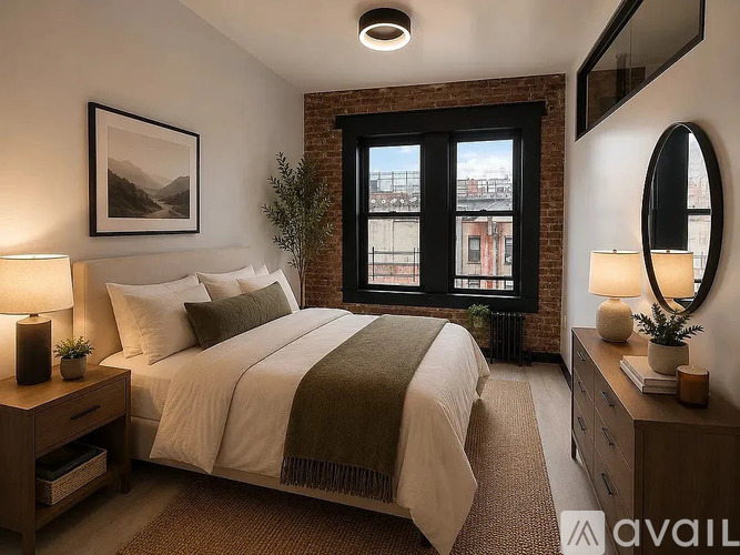 A bedroom with a large bed, a window with a view, and a lamp on the nightstand.