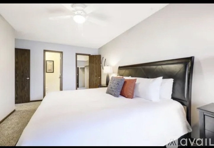 A bedroom with a large bed and a ceiling fan.