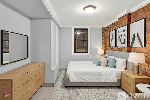 A bedroom with a bed, nightstand, and a dresser with a mirror.