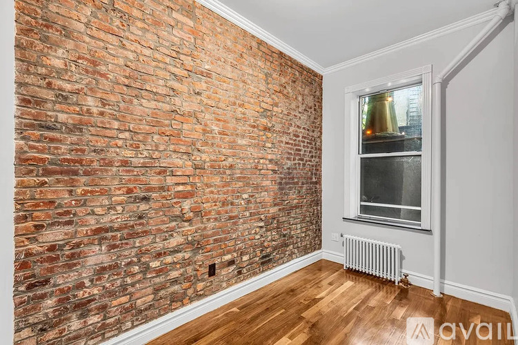 A room with a brick wall and a window.