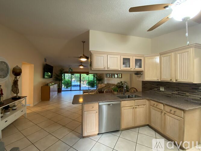 A kitchen with wooden cabinets and a stainless steel dishwasher.