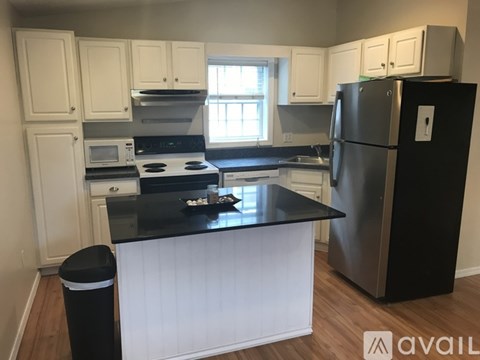 A kitchen with black countertops and white cabinets.