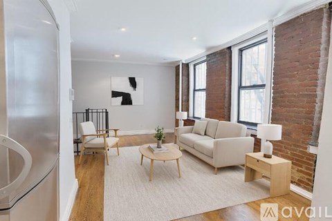 A living room with a couch, chair, and a table with a plant on it.
