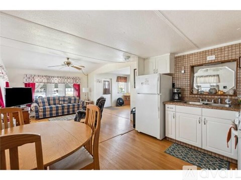 A kitchen with a white refrigerator and wooden floors.