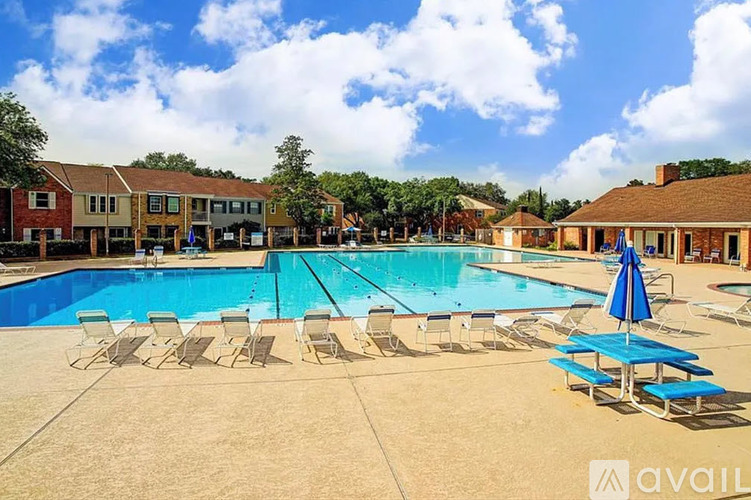 A large swimming pool surrounded by sun loungers and umbrellas.