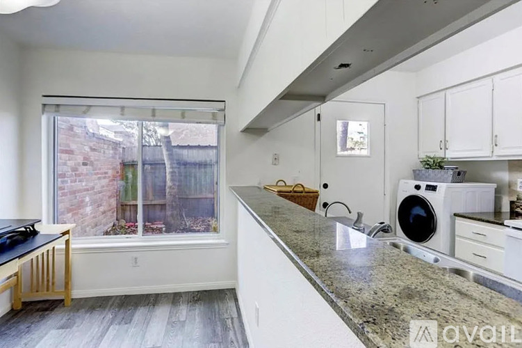 A kitchen with a washing machine in the corner.