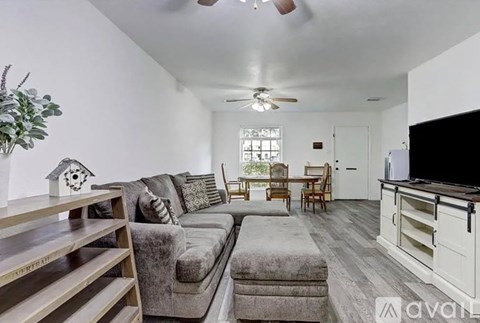 A living room with a grey couch and a wooden shelf.
