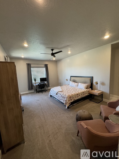 A bedroom with a large bed and a ceiling fan.