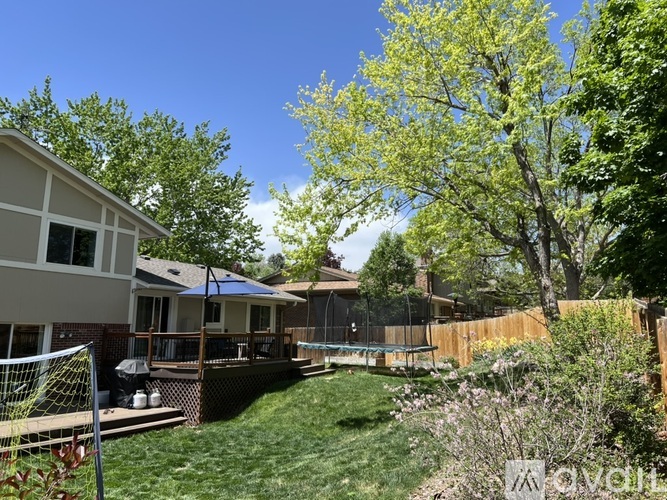A backyard with a wooden fence and a tree with green leaves.
