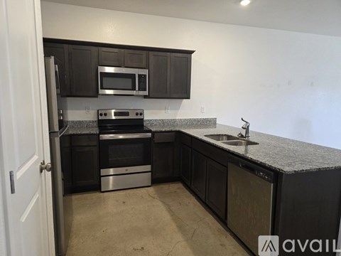 A kitchen with black cabinets and stainless steel appliances.