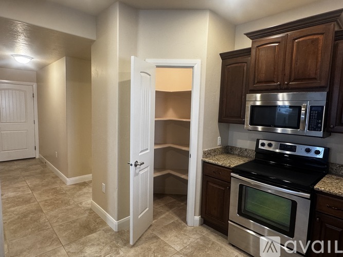 A kitchen with a stove, microwave, and oven.