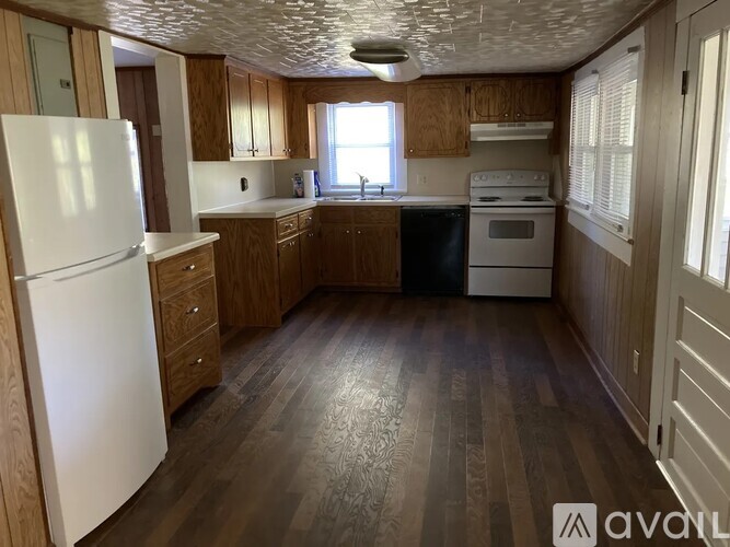 A kitchen with wooden floors and white appliances.