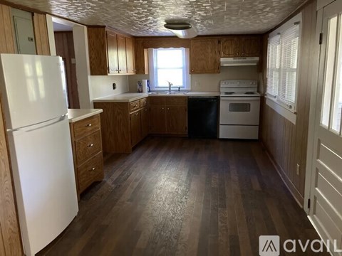 A kitchen with wooden floors and white appliances.
