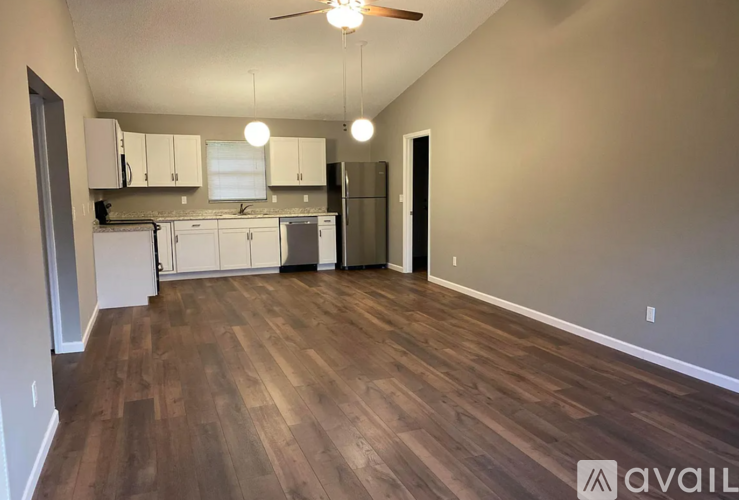 A kitchen with white cabinets and a refrigerator.
