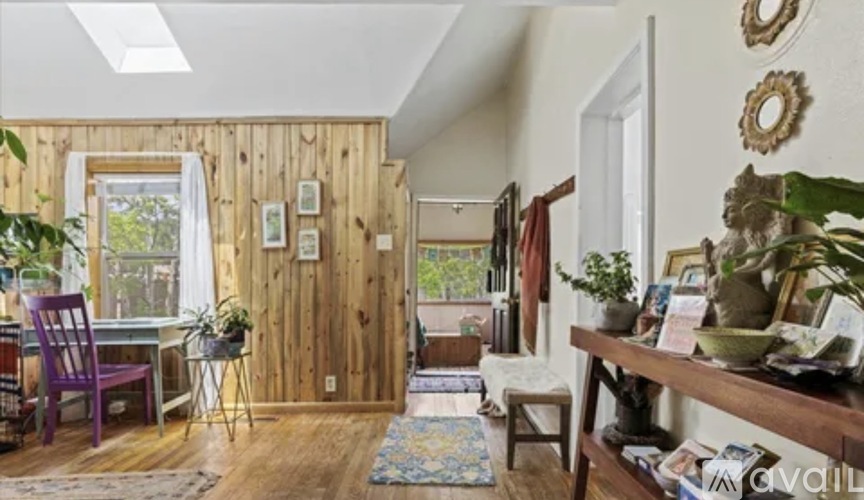 A bedroom with a bed, a small table, and a window.