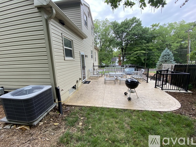 A backyard with a grill and a pool.