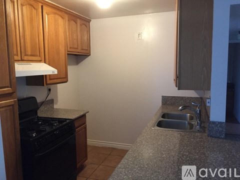 A kitchen with wooden cabinets and a black stove top oven.