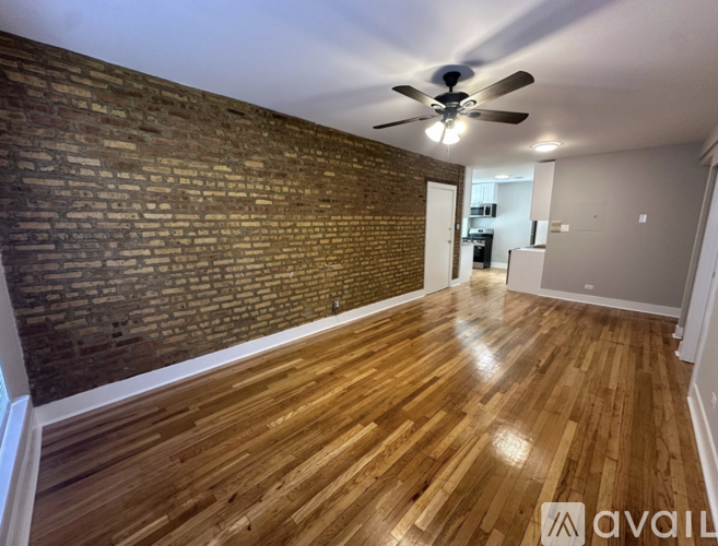 A room with wooden floors and a brick wall.