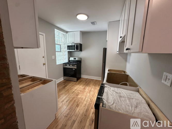 A small bedroom with a bed, a microwave, and a stove.